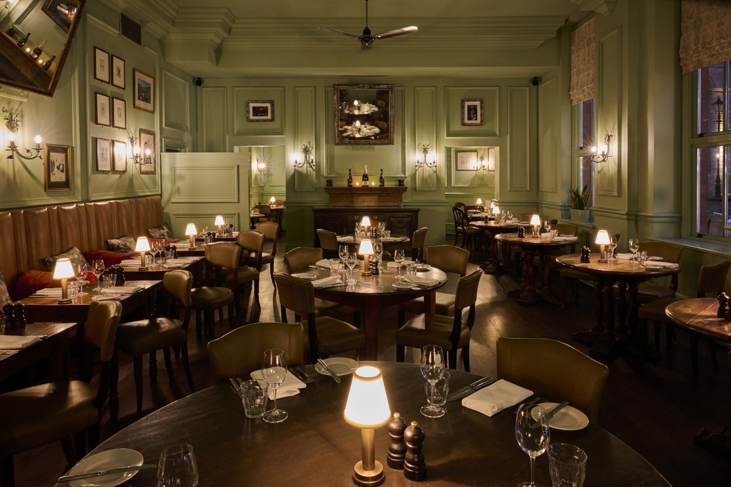 A prepared lowly lit dining hall with wooden tables and chairs