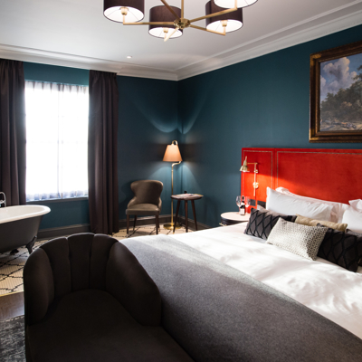 Spacious bedroom featuring a king-sized bed and an elegant bathtub.