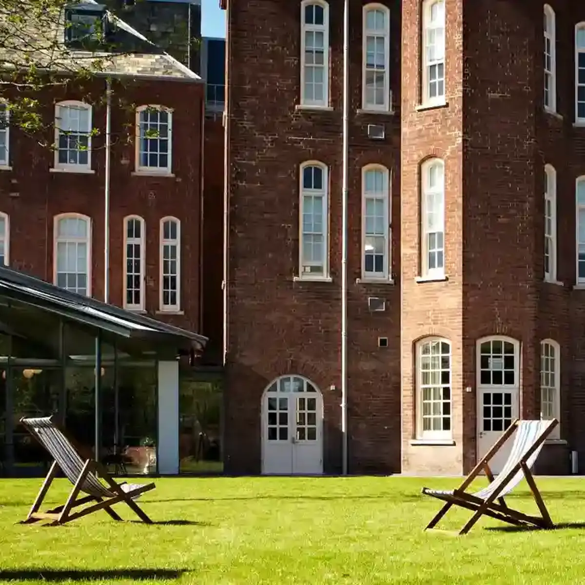 A spacious brick building with a well-maintained lawn in the foreground.