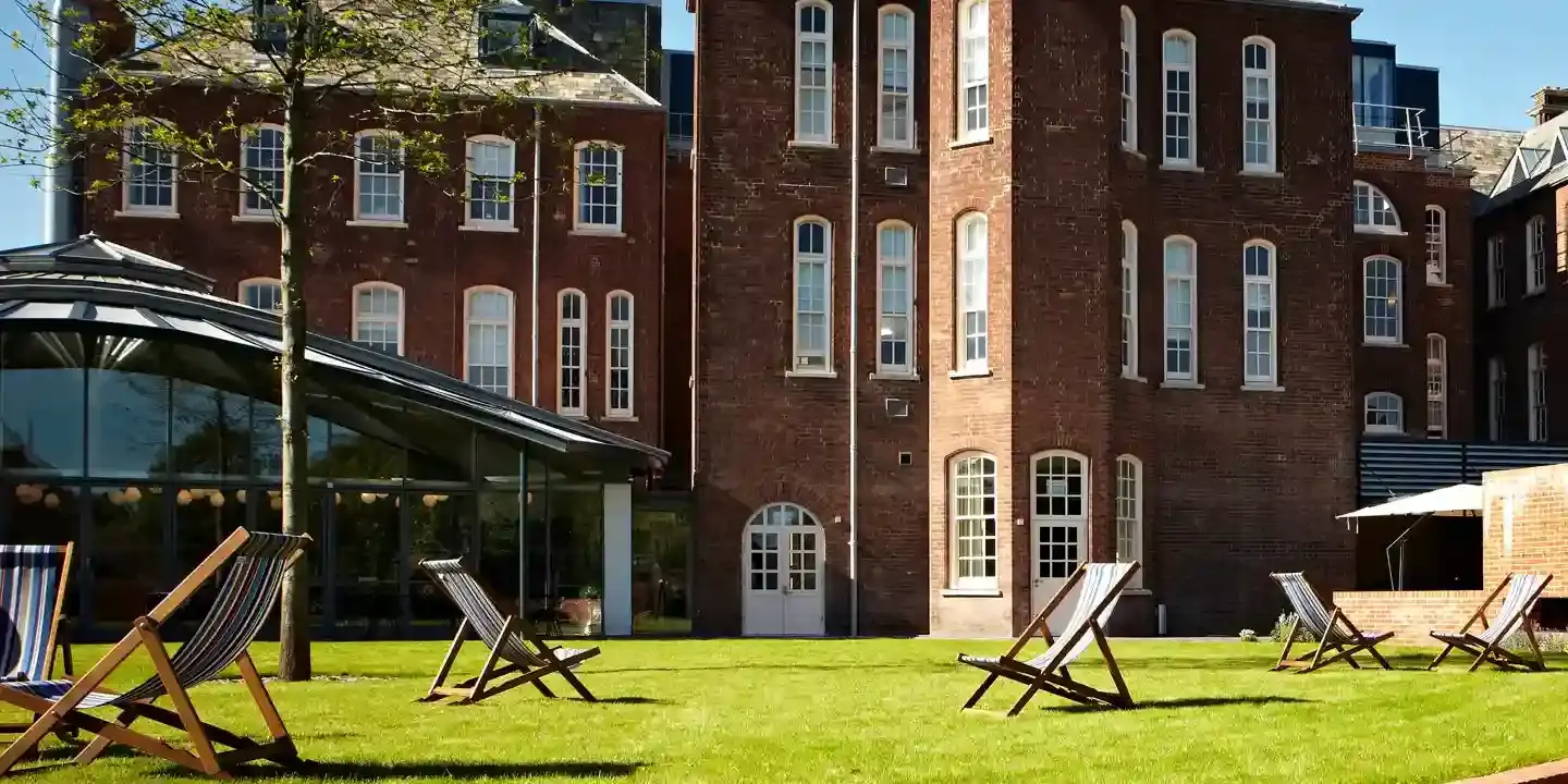 A spacious brick building with a well-maintained lawn in the foreground.