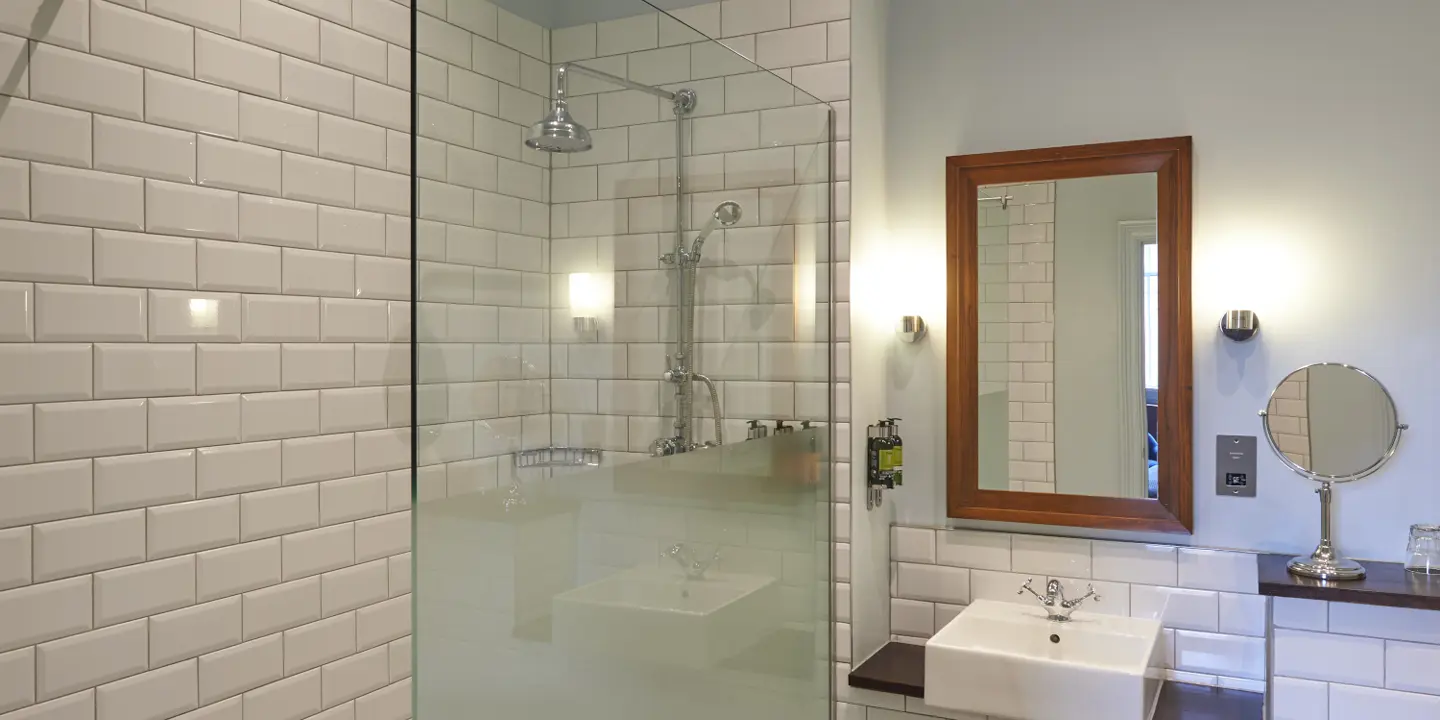 A bathroom with waterfall shower and large sink area