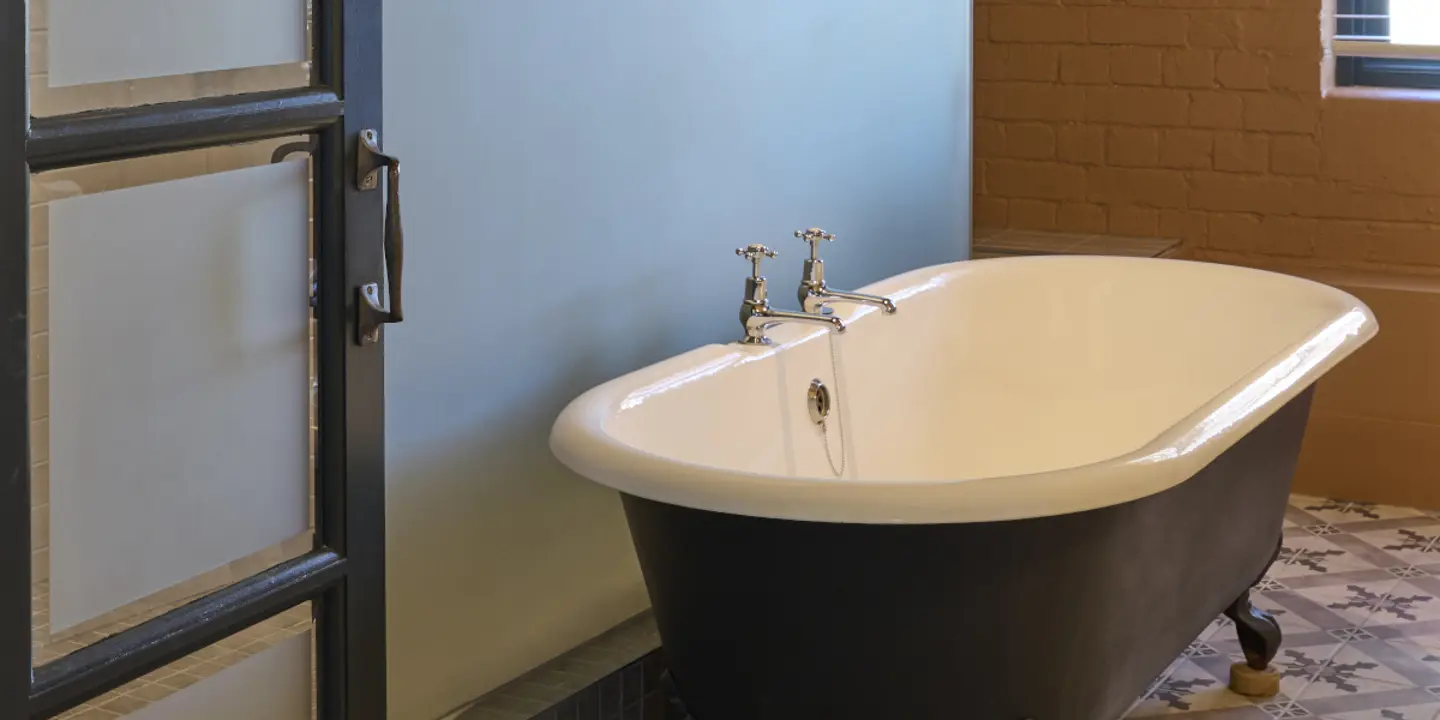 A bathroom featuring a bathtub, sink, and mirror.