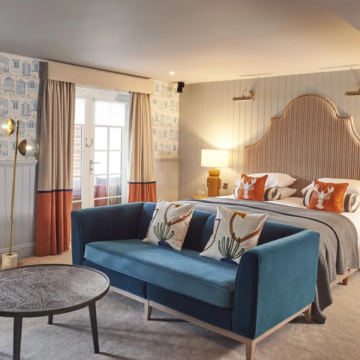 Bedroom featuring a comfortable bed and a stylish blue couch.