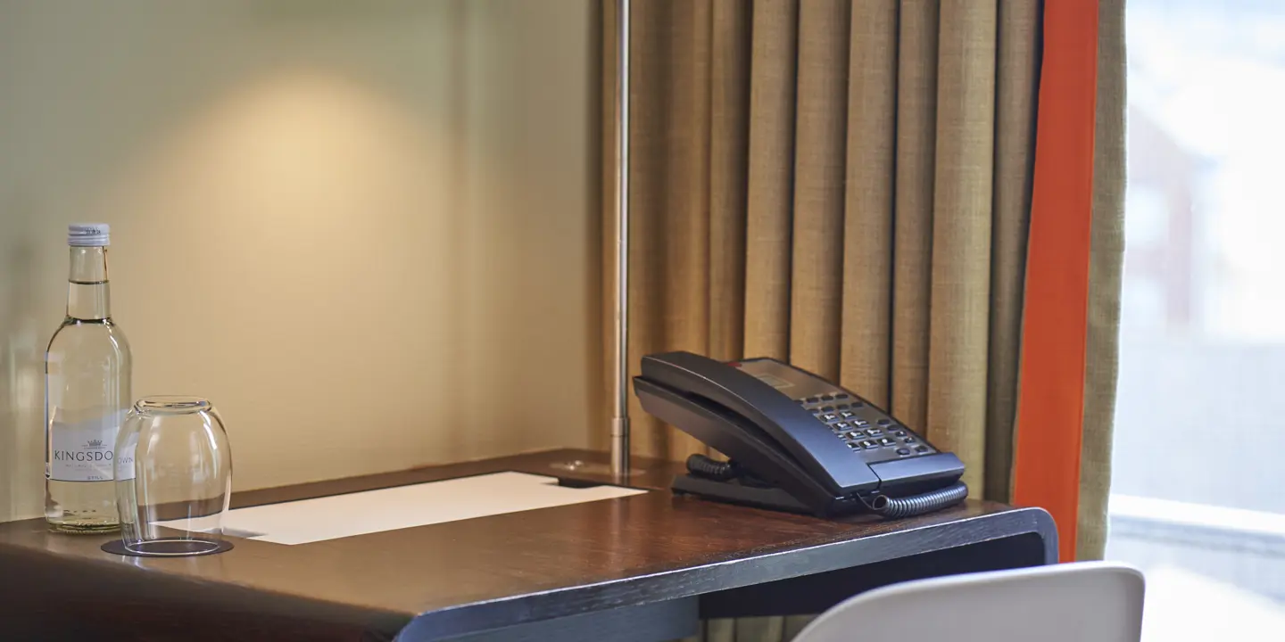 Desk featuring a telephone and a bottle of water