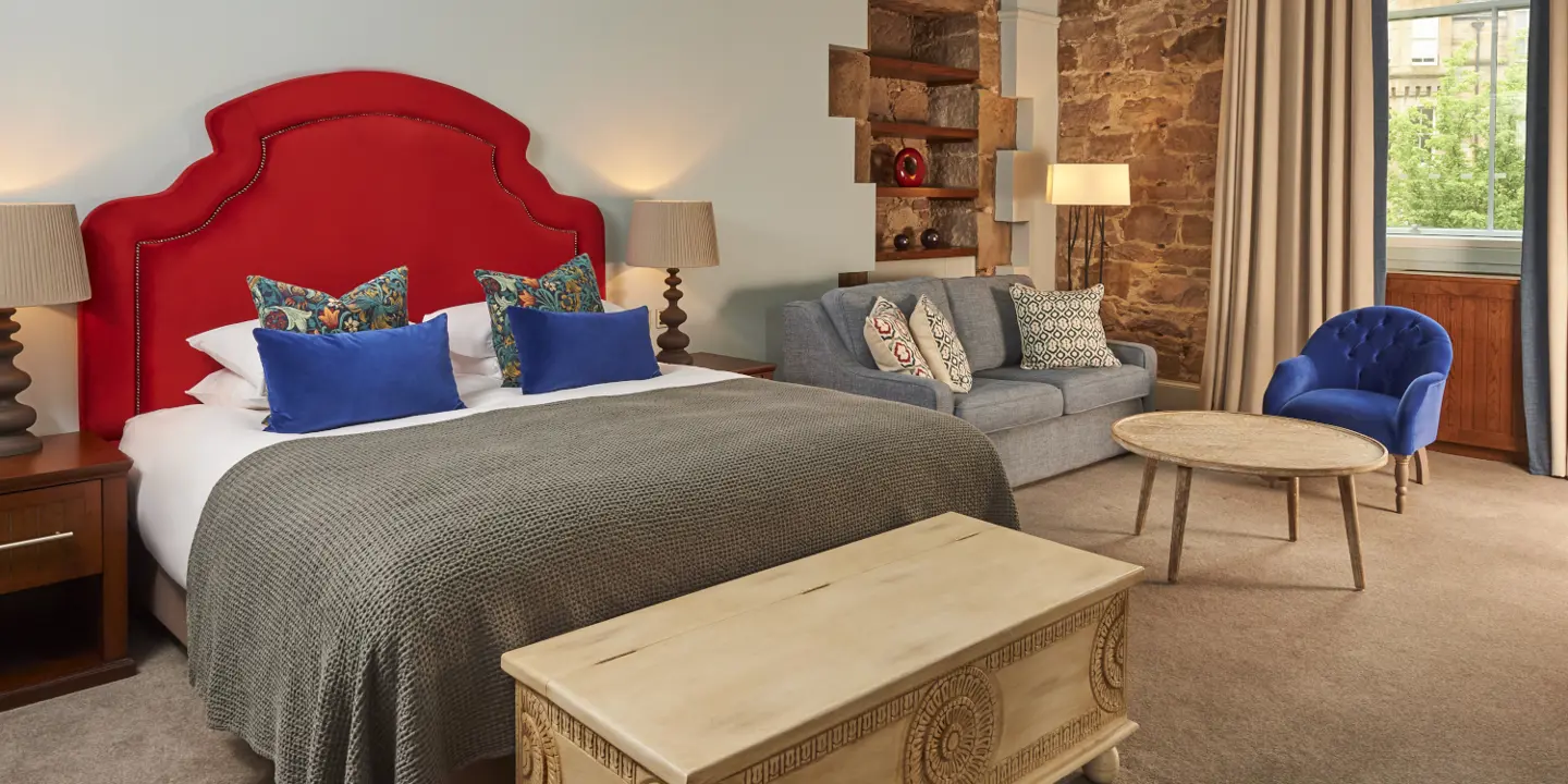 An elegantly furnished bedroom featuring a comfortable couch and a cozy bed.