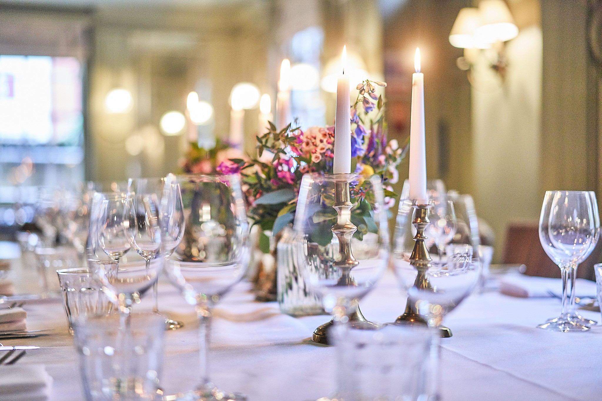 Table set for a formal dinner with candles and flowers.