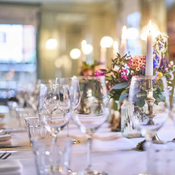 Table set for a formal dinner with candles and flowers.