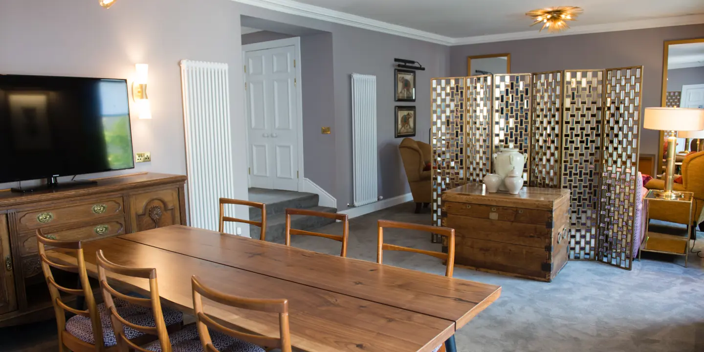 A well-furnished living room featuring a television and a dining table.