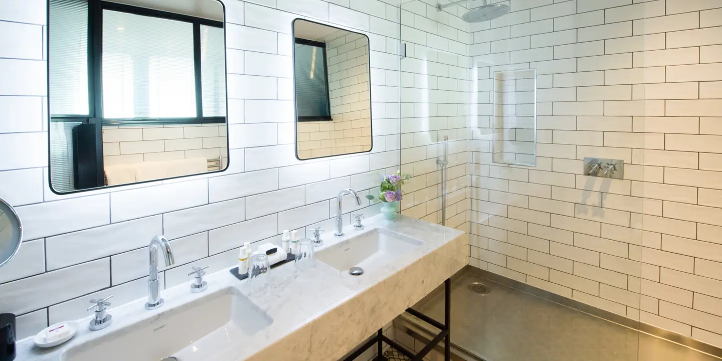 Bathroom featuring two sinks and a shower.