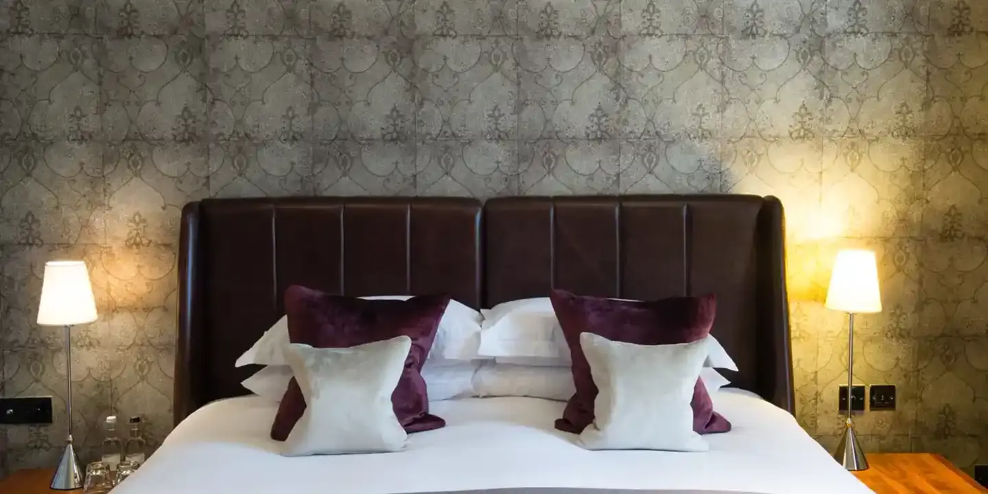 Bed adorned with purple and white cushions