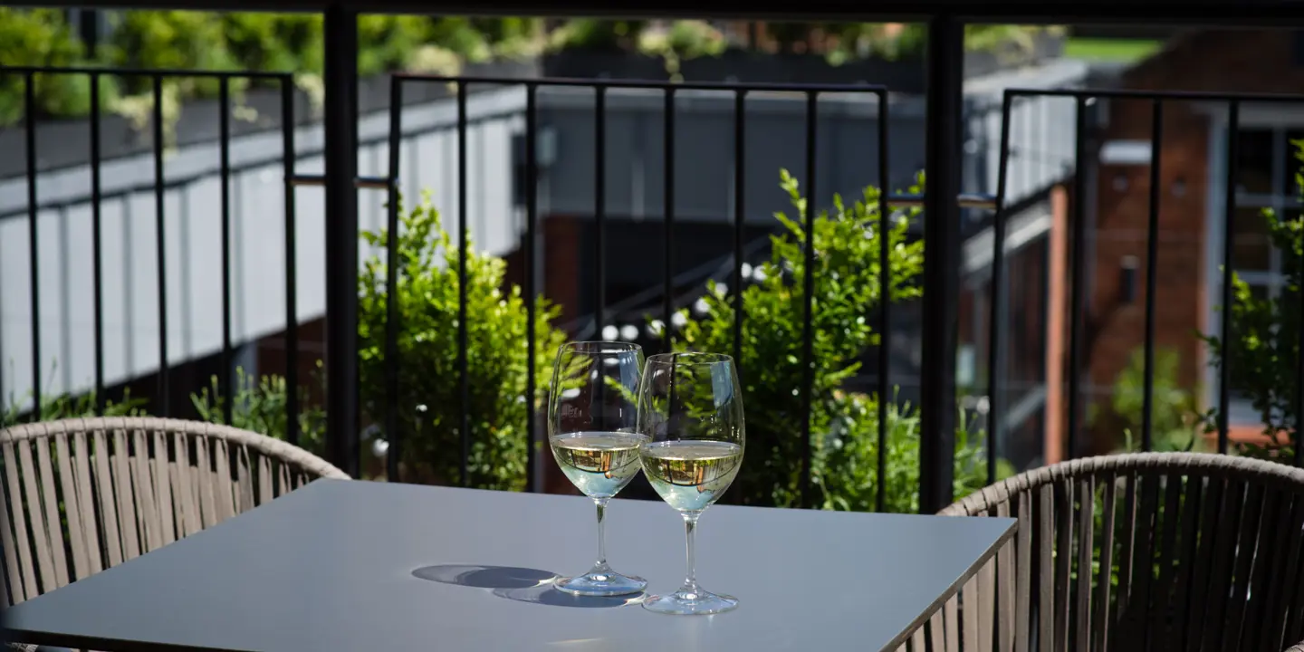 Two wine glasses placed on a table outside.