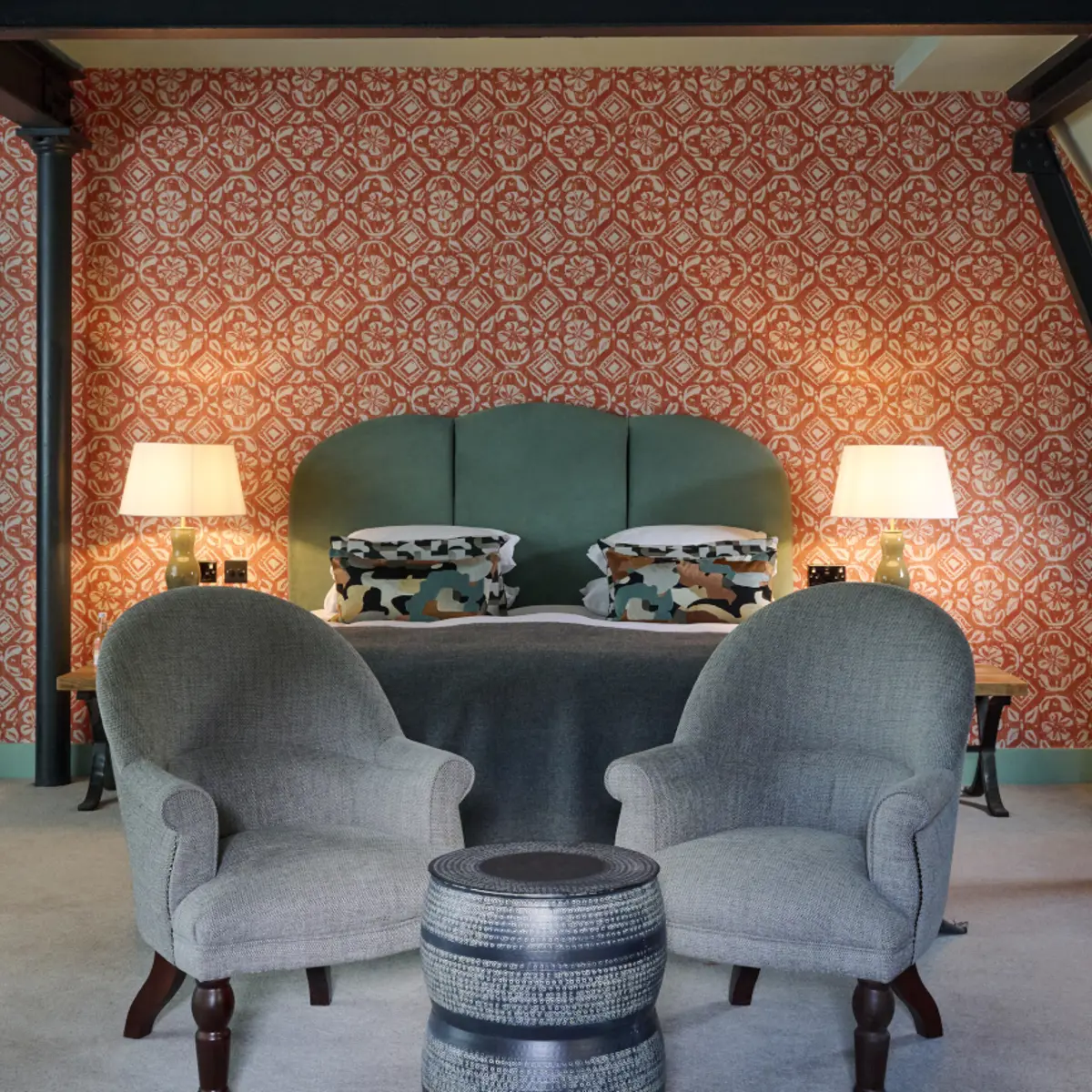 An elegantly furnished hotel room featuring a comfortable bed and a cozy fireplace.