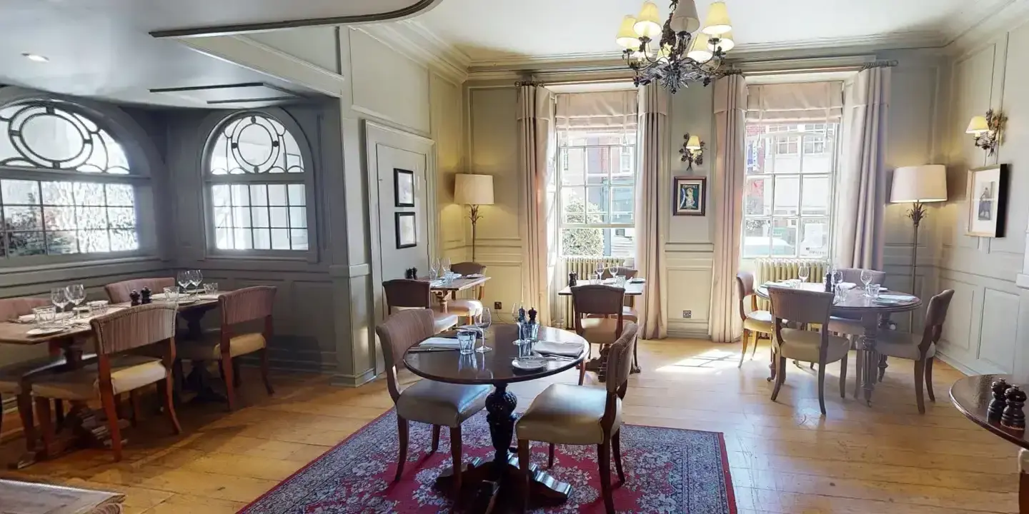 A well-furnished dining room adorned with a magnificent chandelier.