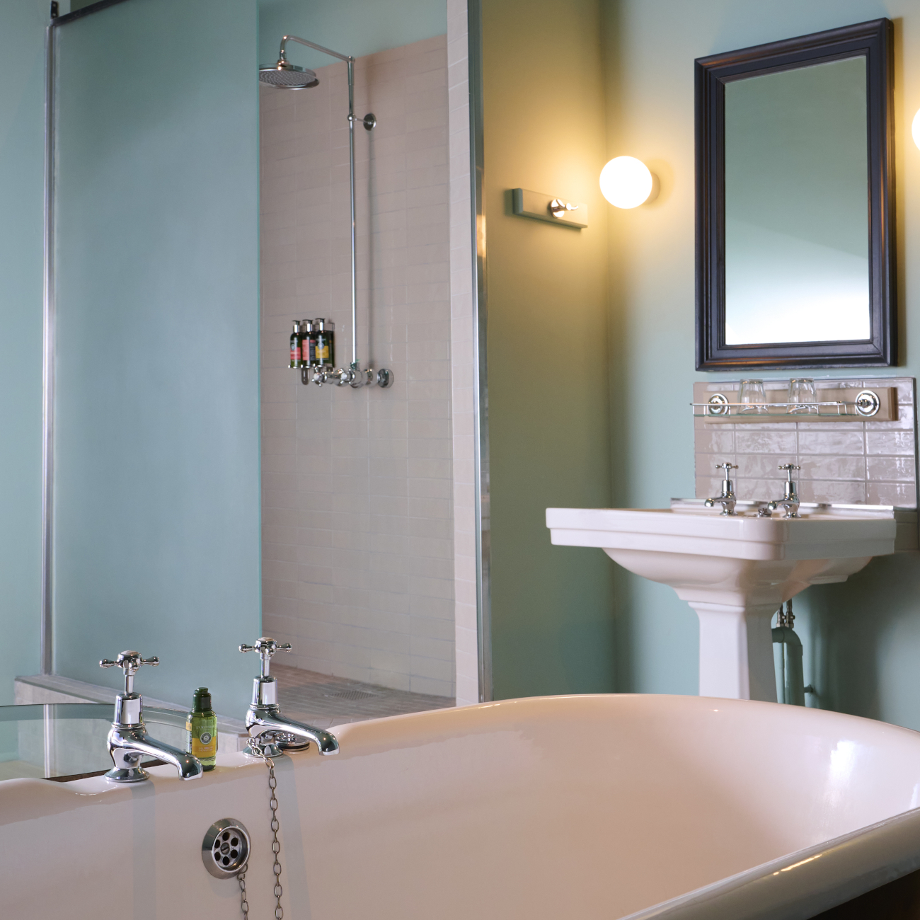 Bathroom featuring a large bathtub, sink, and mirror.
