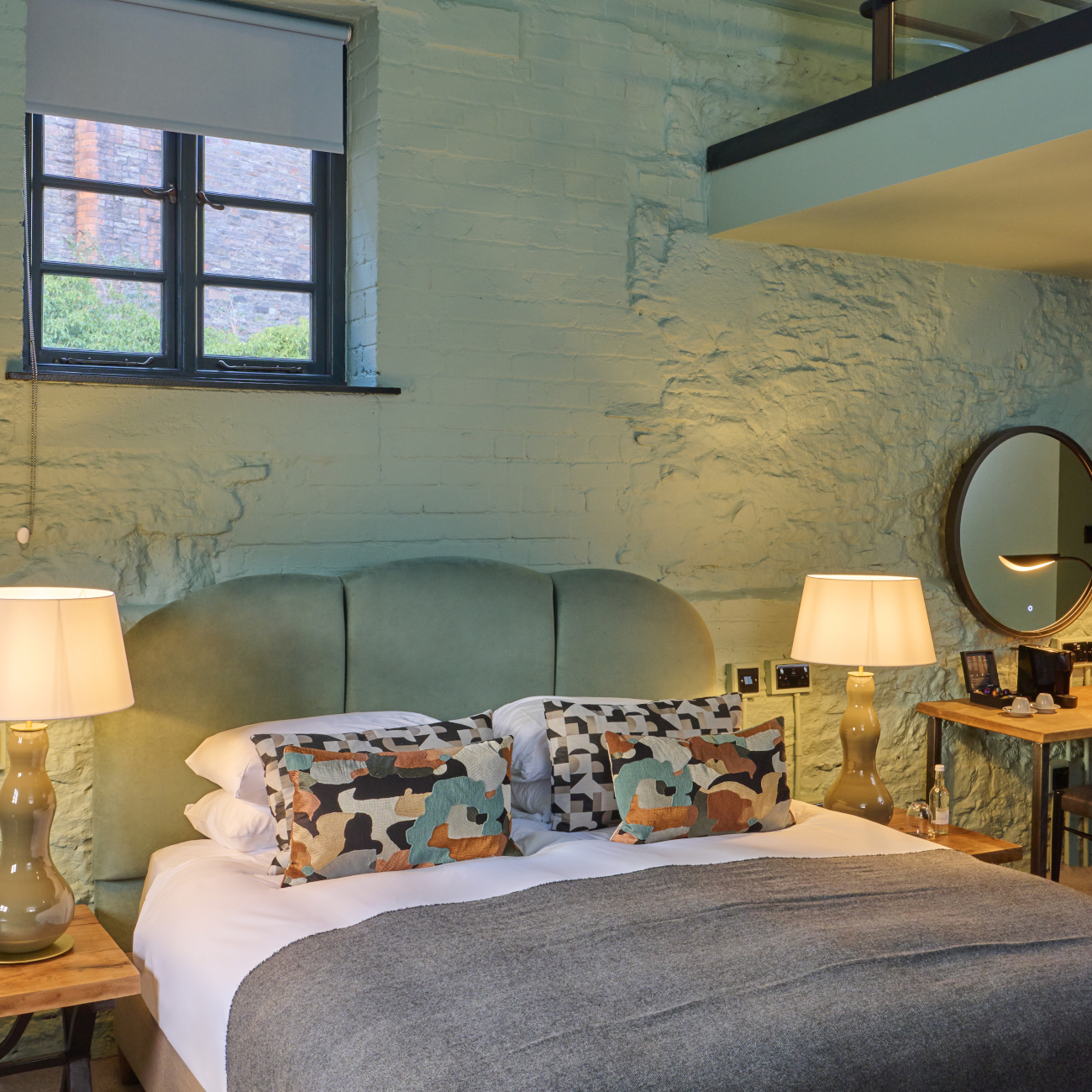 An elegantly furnished hotel room featuring a comfortable bed, stylish chairs, sleek table, and captivating painting.