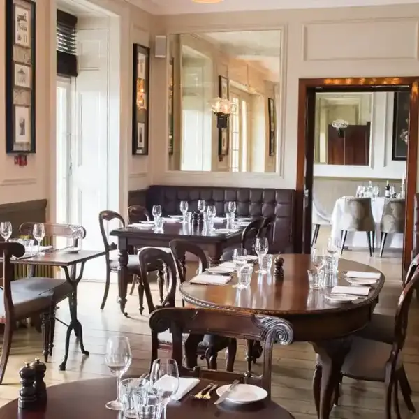 A restaurant featuring tables, chairs, and mirrors.