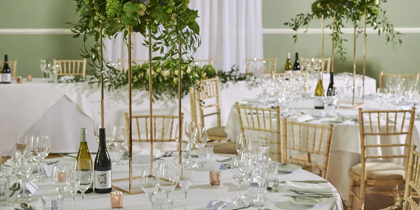 tables set for wedding breakfast with bottles of wine and beautiful flower arrangements