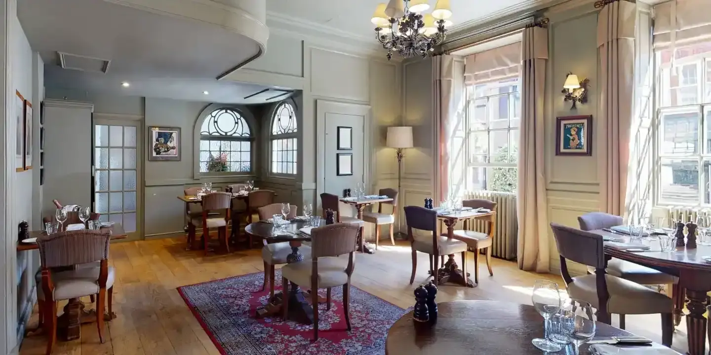 A dining room featuring an elegant chandelier hanging from the ceiling.