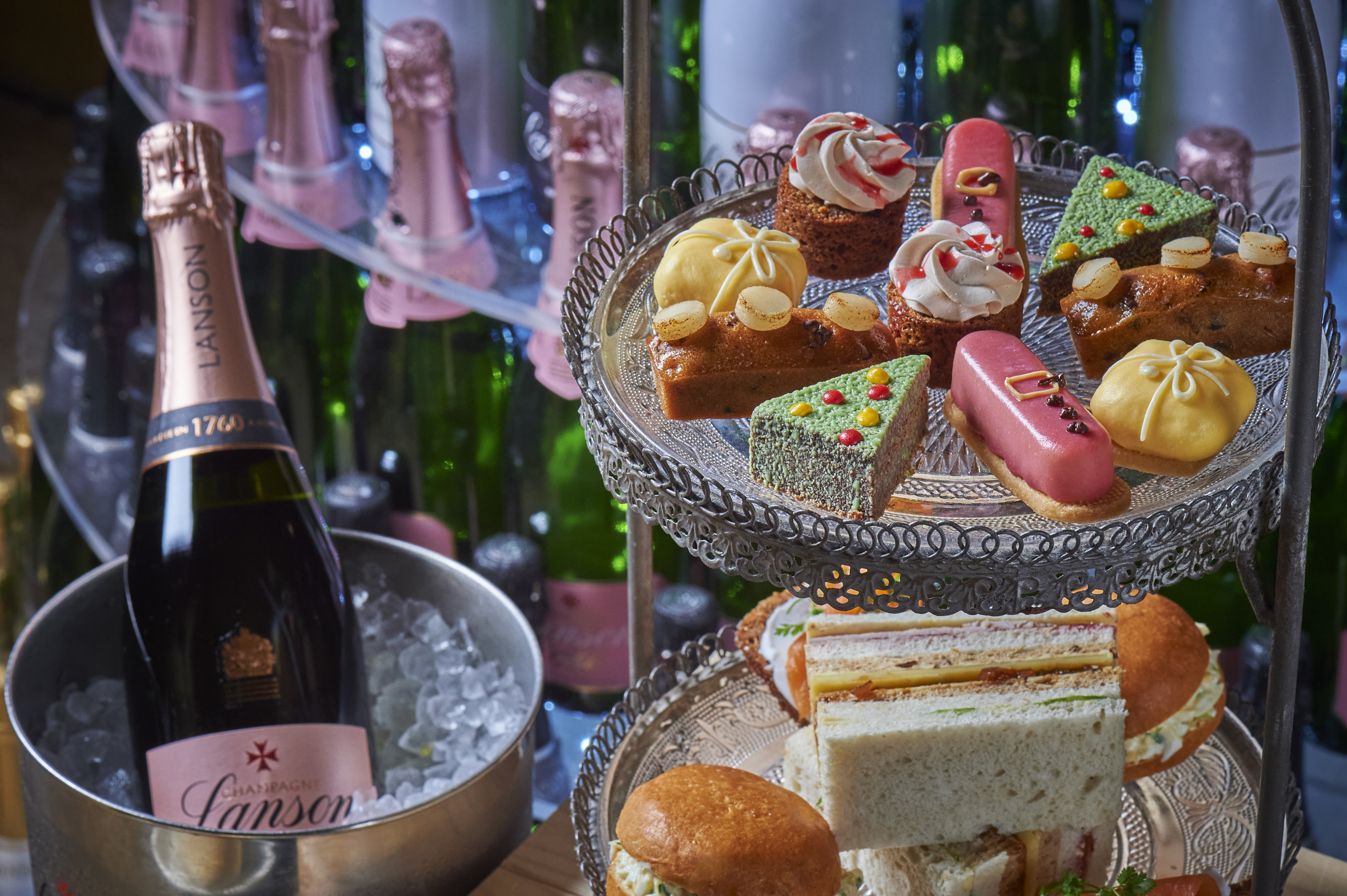 A variety of cakes and light bites and a bottle of champagne