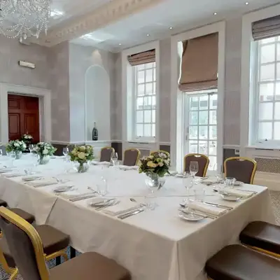 A beautifully arranged long white dining table with elegant place settings.