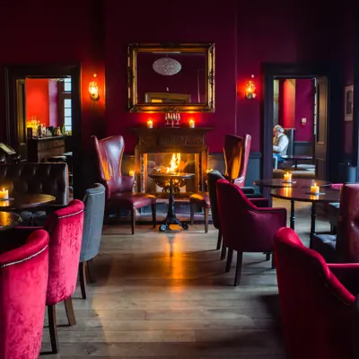 An elegantly furnished room featuring a centrally positioned fireplace.