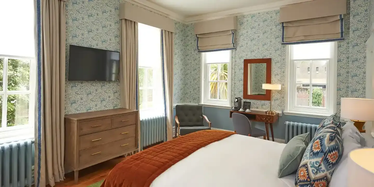 Neatly arranged bedroom featuring a well-made bed and a flat-screen TV.