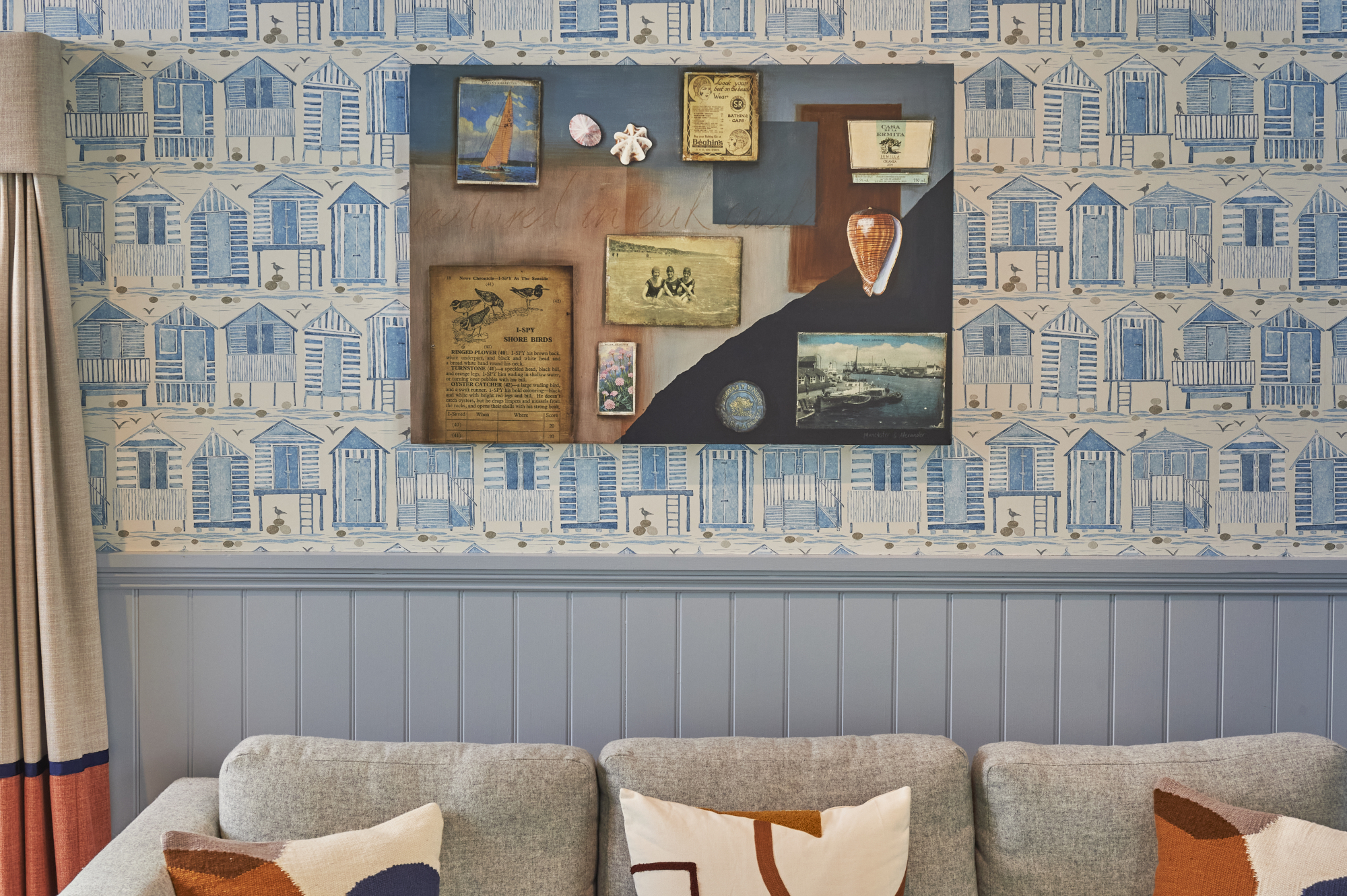 A sofa positioned in front of a wall adorned with photographs.