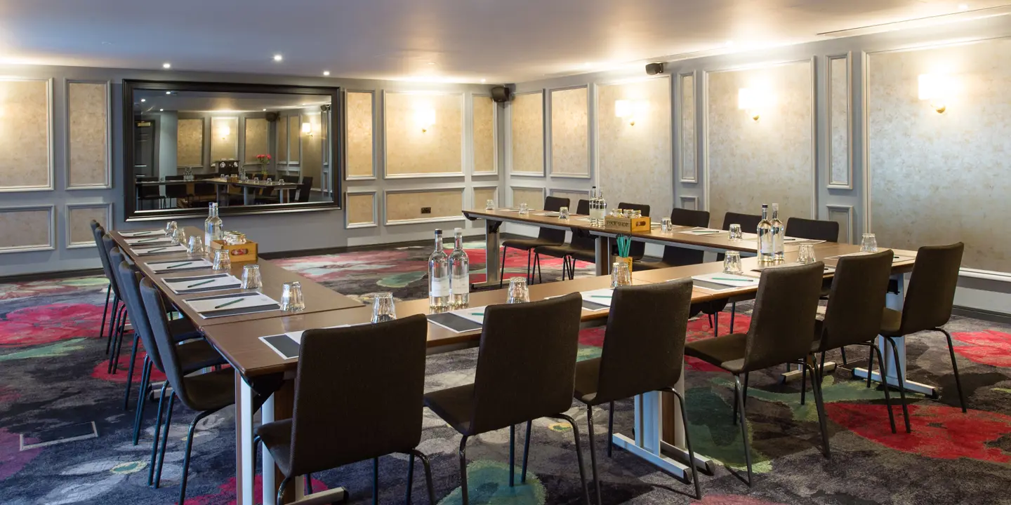 A spacious room featuring a lengthy table accompanied by chairs.