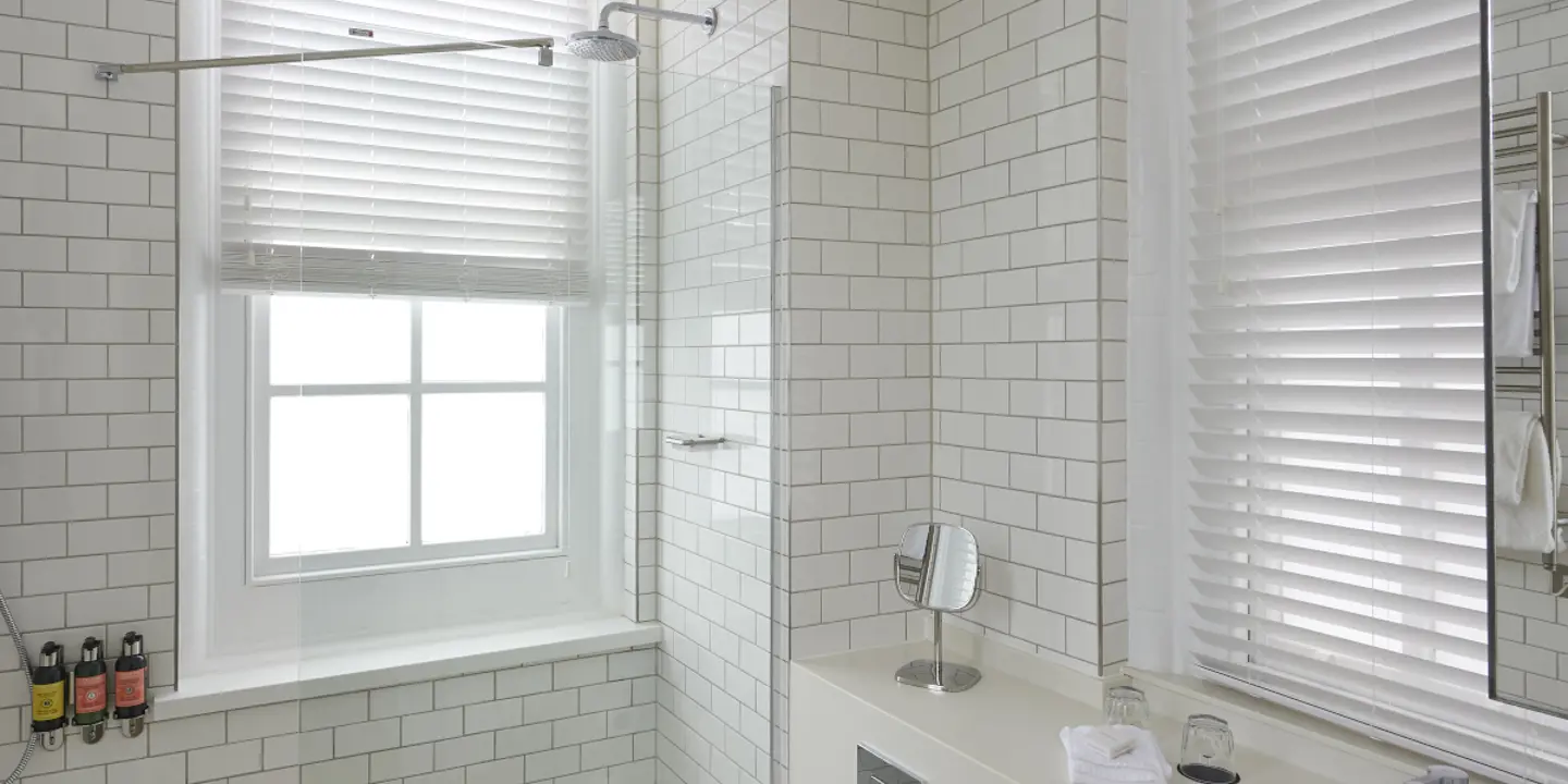 A bathroom featuring a sink, shower, and window.