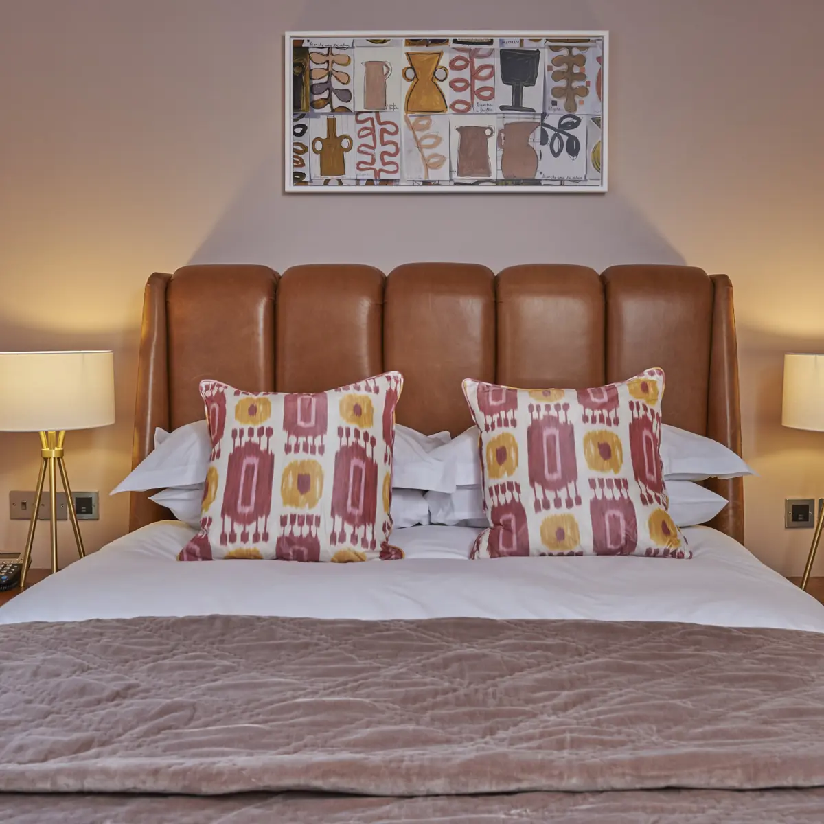 A bed featuring a brown headboard and matching pillows.