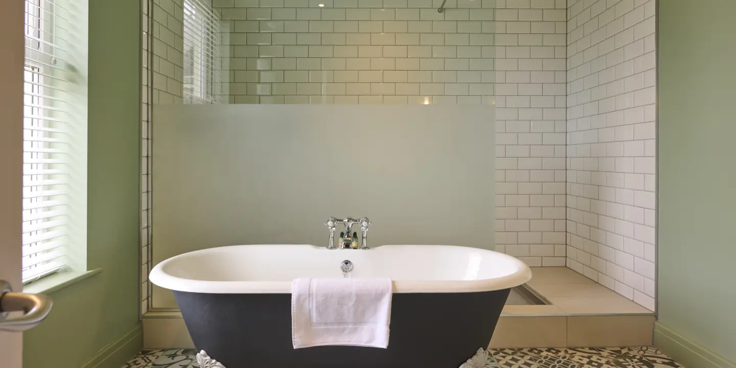 A spacious bathroom decorated with a bath and a large shower