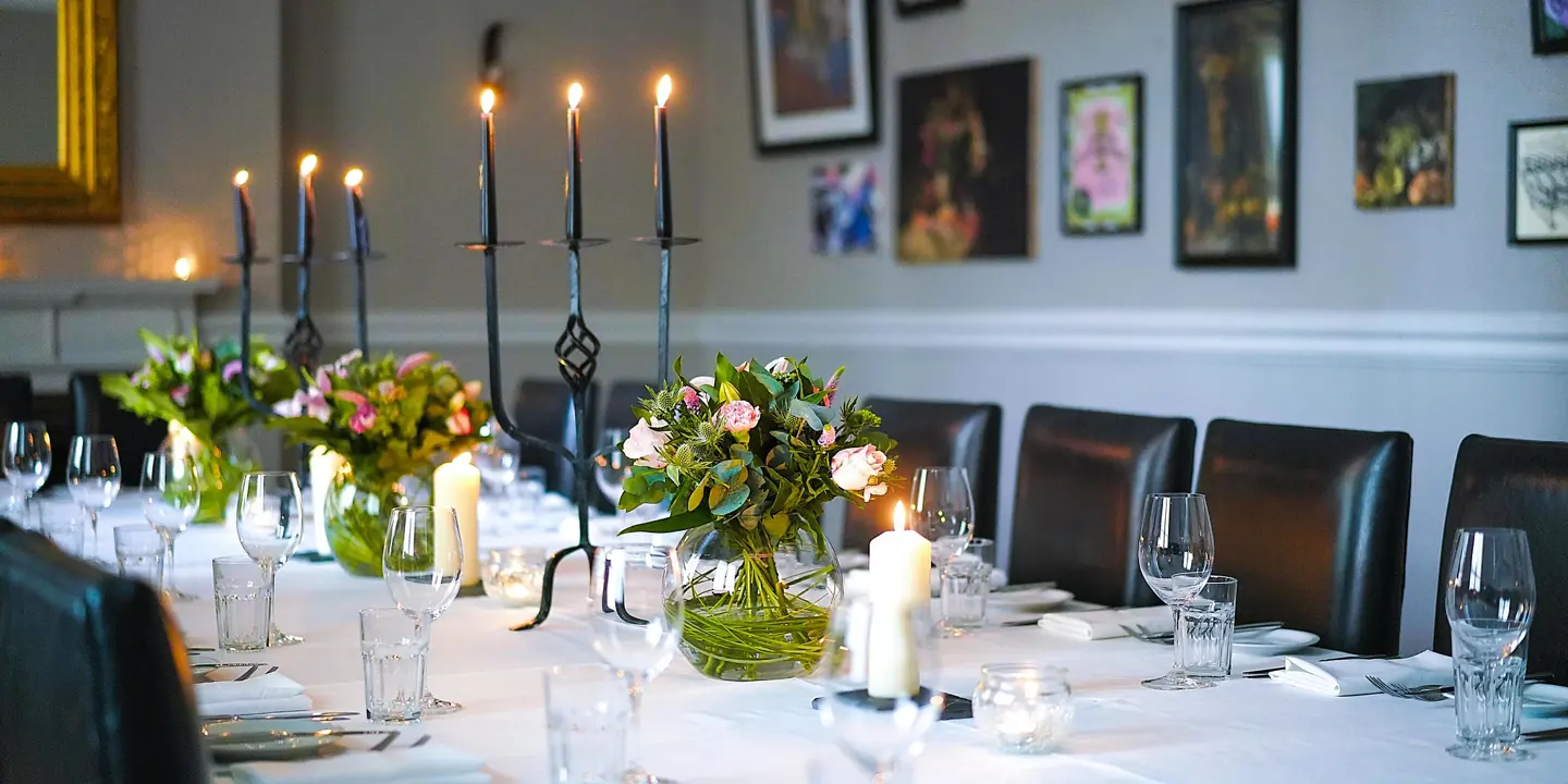 A beautifully adorned table with elegant candles and vibrant flowers.