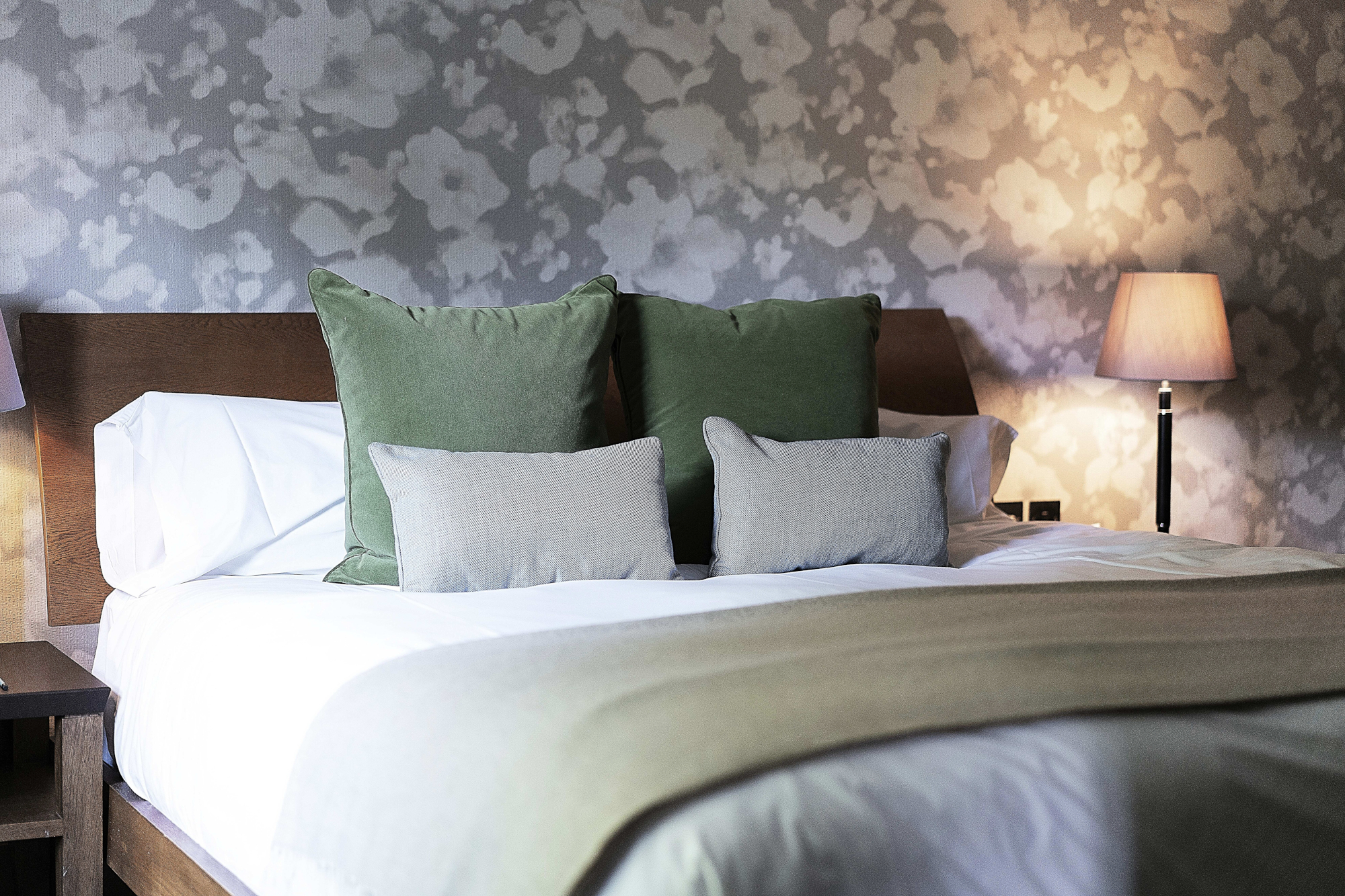 Bedroom with a bed and two lamps on either side.