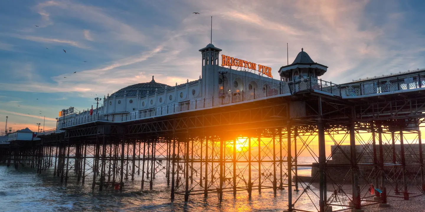 A building atop a pier with the sunsetting behind.