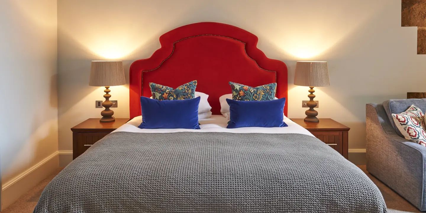 A suite decorated with warm colours, there is a sofa next to the bed