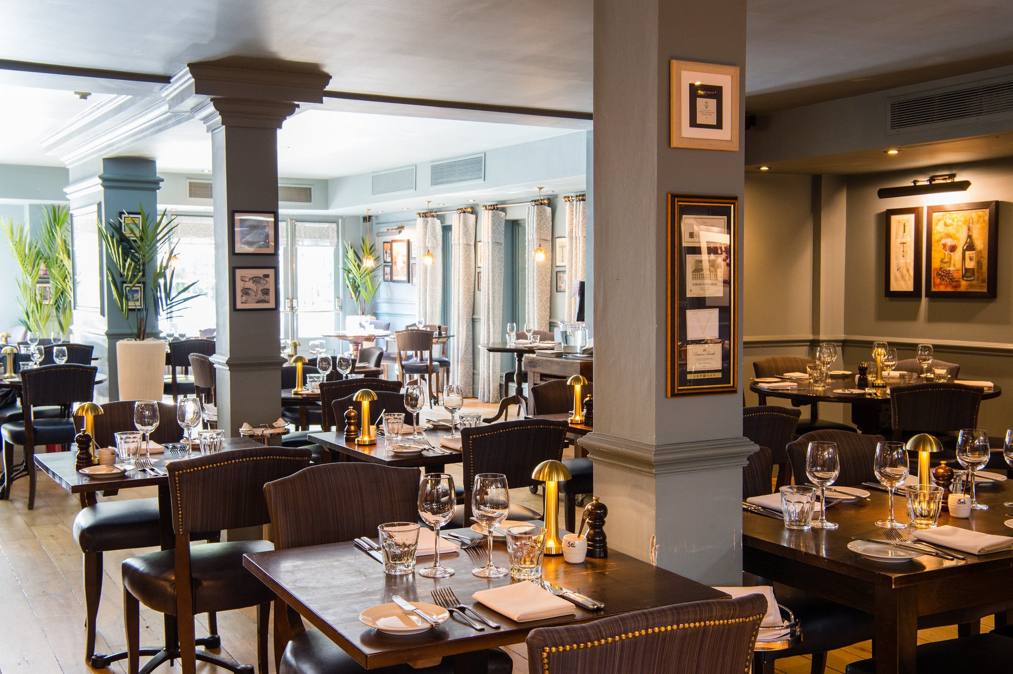 A restaurant featuring tables, chairs, and wine glasses.